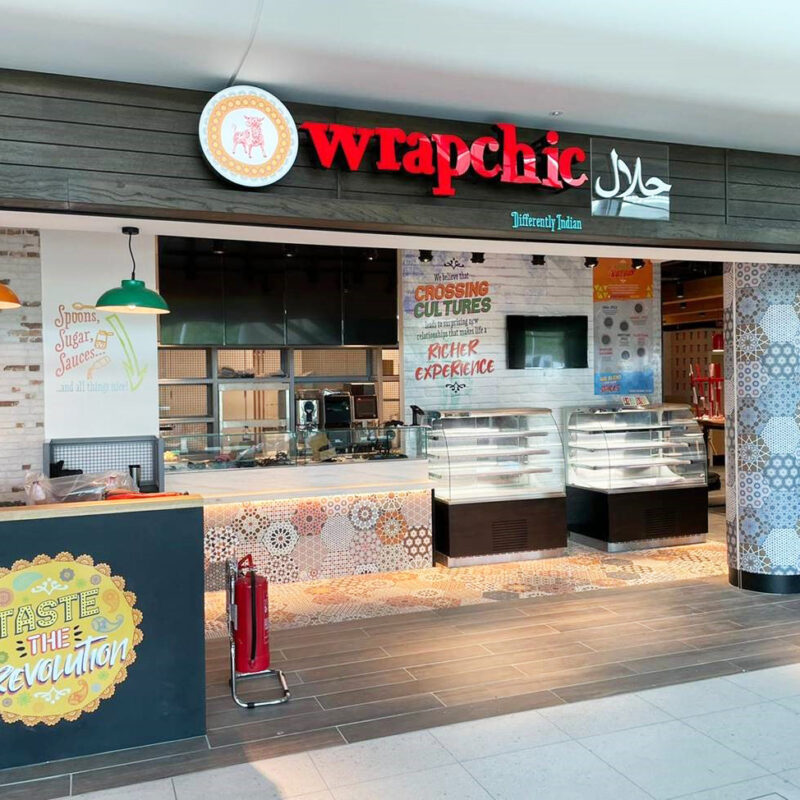 Building trust with property signage: Vibrant Wrapchic signage at Manchester Airport Terminal 2, showcasing impactful branding and large-format property signage.